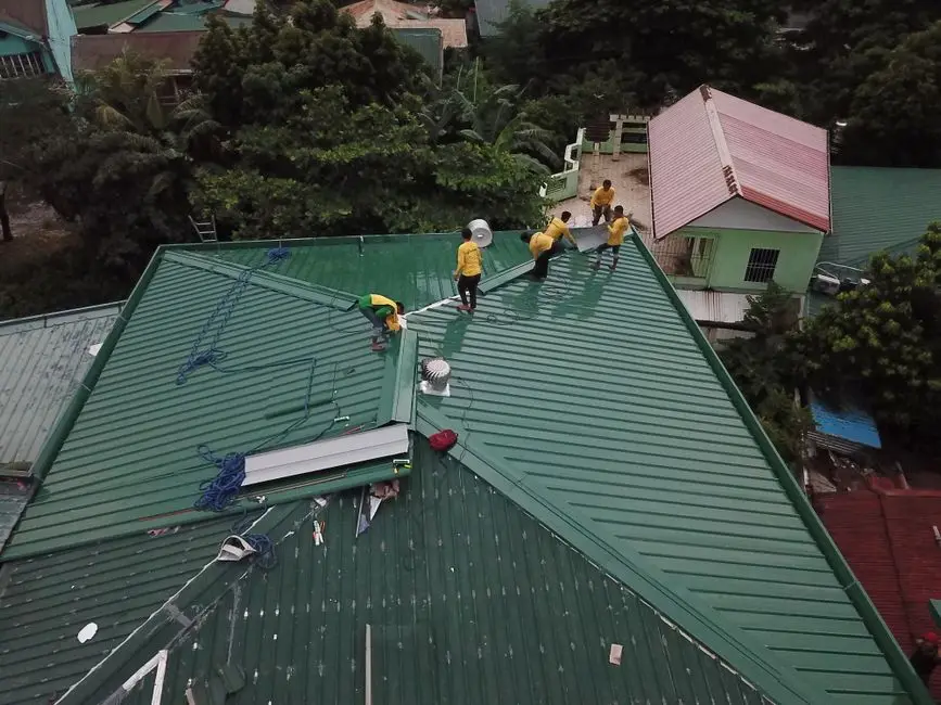 Workers installing green roof panels in Caloocan, Philippines.